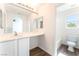 Modern bathroom with white cabinets, a large mirror, and wood-style flooring at 5340 Santa Fe Heights St, North Las Vegas, NV 89081