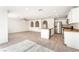 Open-concept kitchen with stainless steel appliances, white cabinets, a breakfast bar, and wood-look tile flooring at 5340 Santa Fe Heights St, North Las Vegas, NV 89081