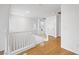 Upstairs hallway with wood floors, bright natural light, and white wood railing at 5526 Spruce Hill Ct, Las Vegas, NV 89148