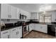 Modern kitchen featuring granite countertops, stainless steel appliances, and white cabinets at 5905 Paseo Montana, Las Vegas, NV 89108