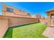 Spacious backyard featuring well-maintained artificial grass and a fenced perimeter for privacy at 6335 Pacific Sky St, North Las Vegas, NV 89081