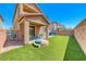 A well-maintained backyard featuring lush artificial grass and an inviting covered patio at 6335 Pacific Sky St, North Las Vegas, NV 89081