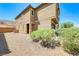 Exterior of home showing a low maintenance backyard with gravel and a variety of desert plants at 6335 Pacific Sky St, North Las Vegas, NV 89081