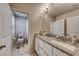 Well-lit bathroom boasts a granite countertop and white cabinets, creating a fresh and clean space at 6335 Pacific Sky St, North Las Vegas, NV 89081