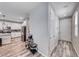 Hallway with wood floors leads into a spacious, modern kitchen featuring stainless steel appliances at 6335 Pacific Sky St, North Las Vegas, NV 89081
