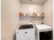 The laundry room features modern appliances and storage shelves for efficient organization at 6335 Pacific Sky St, North Las Vegas, NV 89081