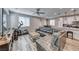 Open-concept living room features wood-look floors, a ceiling fan, and a comfortable sectional sofa at 6335 Pacific Sky St, North Las Vegas, NV 89081