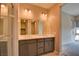 Bright bathroom featuring a double sink vanity with gray cabinetry and an adjacent bedroom with a large window at 646 Spotted Falcon St, Las Vegas, NV 89138