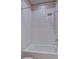 White tiled shower-tub combo with a shower head and modern fixtures at 646 Spotted Falcon St, Las Vegas, NV 89138