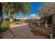 Landscaped backyard with mature trees, decorative elements, and gravel pathway at 6513 Hyde Ave, Las Vegas, NV 89107