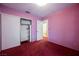 Bedroom with pink walls, red carpet, and a closet at 6513 Hyde Ave, Las Vegas, NV 89107