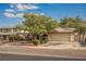 Charming single-story home featuring arched entryways, a well-manicured yard, mature shade tree, and attached two-car garage at 6513 Hyde Ave, Las Vegas, NV 89107