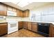 Kitchen featuring wood cabinetry, white appliances, and vintage design elements at 6513 Hyde Ave, Las Vegas, NV 89107