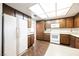 Functional kitchen features abundant cabinetry, white appliances, and a light-filled skylight at 6513 Hyde Ave, Las Vegas, NV 89107