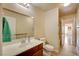 Bathroom with wood vanity, large mirror, and wood-look tile flooring at 6656 Arctic Breeze St, North Las Vegas, NV 89084