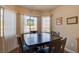 Cozy dining area with a dark wood table set by a bright window at 6656 Arctic Breeze St, North Las Vegas, NV 89084
