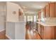 Cozy kitchen featuring wood cabinets, bright countertops, and a breakfast bar that opens to the dining area at 6656 Arctic Breeze St, North Las Vegas, NV 89084