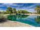 Picturesque pond reflecting lush greenery and blue skies, creating a tranquil and inviting natural setting at 6656 Arctic Breeze St, North Las Vegas, NV 89084