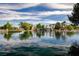A serene pond reflecting the sky, accented by a waterfall and surrounded by lush greenery, offering a tranquil escape at 6656 Arctic Breeze St, North Las Vegas, NV 89084