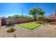 Beautiful putting green in backyard with desert landscaping, mature trees and a block wall at 6656 Arctic Breeze St, North Las Vegas, NV 89084