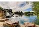 Picturesque Personal-made waterfall cascading into a pond, surrounded by rocks and lush vegetation, creating a serene setting at 6656 Arctic Breeze St, North Las Vegas, NV 89084