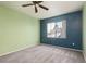 Bedroom featuring two-toned walls, ceiling fan, plush carpet, and view of the neighborhood at 7155 S Durango Dr # 303, Las Vegas, NV 89113