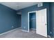 Bedroom with neutral carpet, a closet, and an open doorway at 7155 S Durango Dr # 303, Las Vegas, NV 89113