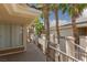Exterior shot of condo walkway featuring stucco columns and black metal railings with palm trees throughout complex at 7155 S Durango Dr # 303, Las Vegas, NV 89113