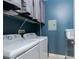 This laundry room features a modern washer and dryer set, with wire shelving, and utility access at 7155 S Durango Dr # 303, Las Vegas, NV 89113