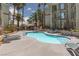 Enjoy the luxurious community pool with lounge chairs, tables, and lush tropical landscaping at 7155 S Durango Dr # 303, Las Vegas, NV 89113