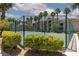 View of the tennis court with green fence and landscaping at 7155 S Durango Dr # 303, Las Vegas, NV 89113