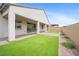Expansive backyard with artificial lawn, brick pavers, covered patio, and desert landscaping at 717 Monroe Hill Pl, Henderson, NV 89011