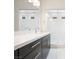 Stylish bathroom with dark cabinets, white countertops, dual sinks, and a glass-enclosed shower at 717 Monroe Hill Pl, Henderson, NV 89011