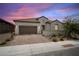 Charming single-story home featuring a brick driveway, neutral stucco, tile roof, and desert landscaping at 717 Monroe Hill Pl, Henderson, NV 89011
