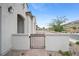 Side angle of a stucco home with a small gated patio area, creating a welcoming entrance at 717 Monroe Hill Pl, Henderson, NV 89011