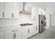 Modern kitchen featuring stainless steel appliances, sleek white cabinets, and elegant backsplash at 717 Monroe Hill Pl, Henderson, NV 89011