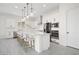 Modern kitchen with white cabinets, an island with bar stool seating, stainless steel appliances, and gray flooring at 717 Monroe Hill Pl, Henderson, NV 89011