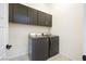 Clean laundry room features modern appliances and black cabinets for ample storage at 717 Monroe Hill Pl, Henderson, NV 89011