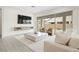 Sunlit living room featuring a large flat-screen TV, stylish decor, and sliding glass doors to the patio at 717 Monroe Hill Pl, Henderson, NV 89011