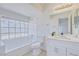 Bathroom features a shower-tub combo, window, and a modern vanity at 7405 Saybrook Point Dr, Las Vegas, NV 89128