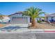 Charming single-story home with a xeriscaped front yard and mature palm tree enhancing its curb appeal at 7405 Saybrook Point Dr, Las Vegas, NV 89128