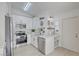 Modern white kitchen with stainless steel appliances, marble countertops, and stylish black fixtures offers an elegant design at 7405 Saybrook Point Dr, Las Vegas, NV 89128