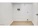 A bright, empty laundry room, ready for appliances, featuring clean white walls and modern wood-look flooring at 7405 Saybrook Point Dr, Las Vegas, NV 89128