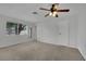 Bright bedroom featuring plush carpet, a ceiling fan, and ample natural light from the large window at 75 N 27Th St, Las Vegas, NV 89101