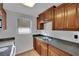 Efficient kitchen layout featuring wood cabinets, granite counters, tiled flooring and modern appliances at 75 N 27Th St, Las Vegas, NV 89101