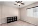 Bright bedroom featuring a ceiling fan, a window with blinds, carpet floors, and a storage shelf at 8860 Hampton Green Ave, Las Vegas, NV 89129