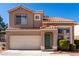 Inviting two-story home showcasing a two-car garage, desert landscaping and a welcoming green front door at 8860 Hampton Green Ave, Las Vegas, NV 89129