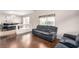 Open living room features wood floors, a comfortable gray sofa, seamlessly connecting to the dining area at 8860 Hampton Green Ave, Las Vegas, NV 89129
