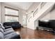 Spacious living room featuring hard wood floors, a gray sofa, and large windows providing plenty of natural light at 8860 Hampton Green Ave, Las Vegas, NV 89129