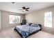 Spacious bedroom with ceiling fan, carpet, and double window views at 8860 Hampton Green Ave, Las Vegas, NV 89129